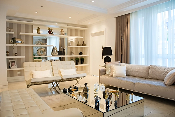 A living room with white furniture and a glass table