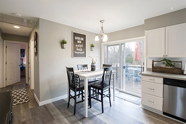 A dining room table with chairs and a sliding glass door.