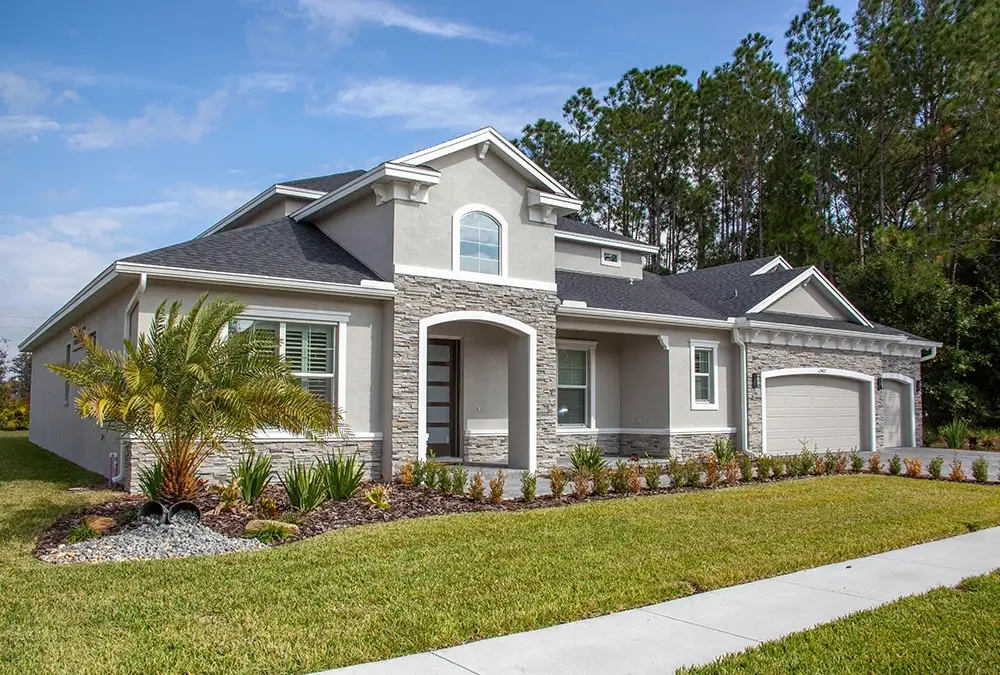 A house with a driveway and palm trees in the background.