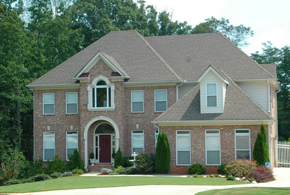 A large brick house with a red door.