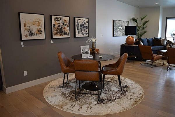 A dining room with brown chairs and a round table.