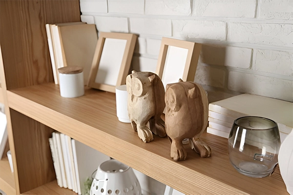 A shelf with two owls on it and some books