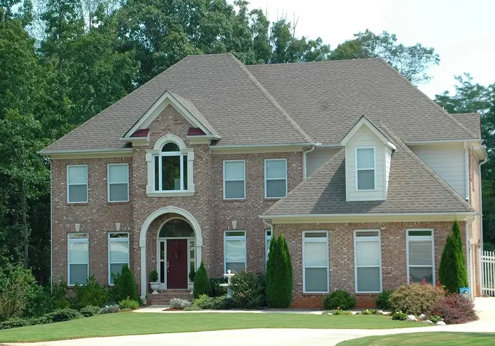 A large brick house with a red door.